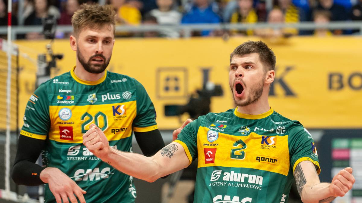 Dw&oacute;ch siatkarzy w zielono-ż&oacute;łtych koszulkach podczas meczu siatk&oacute;wki.