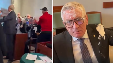 Prezydent Poznania Jacek Jaśkowiak z ciastem na twarzy i garniturze po ataku podczas sesji rady miasta.