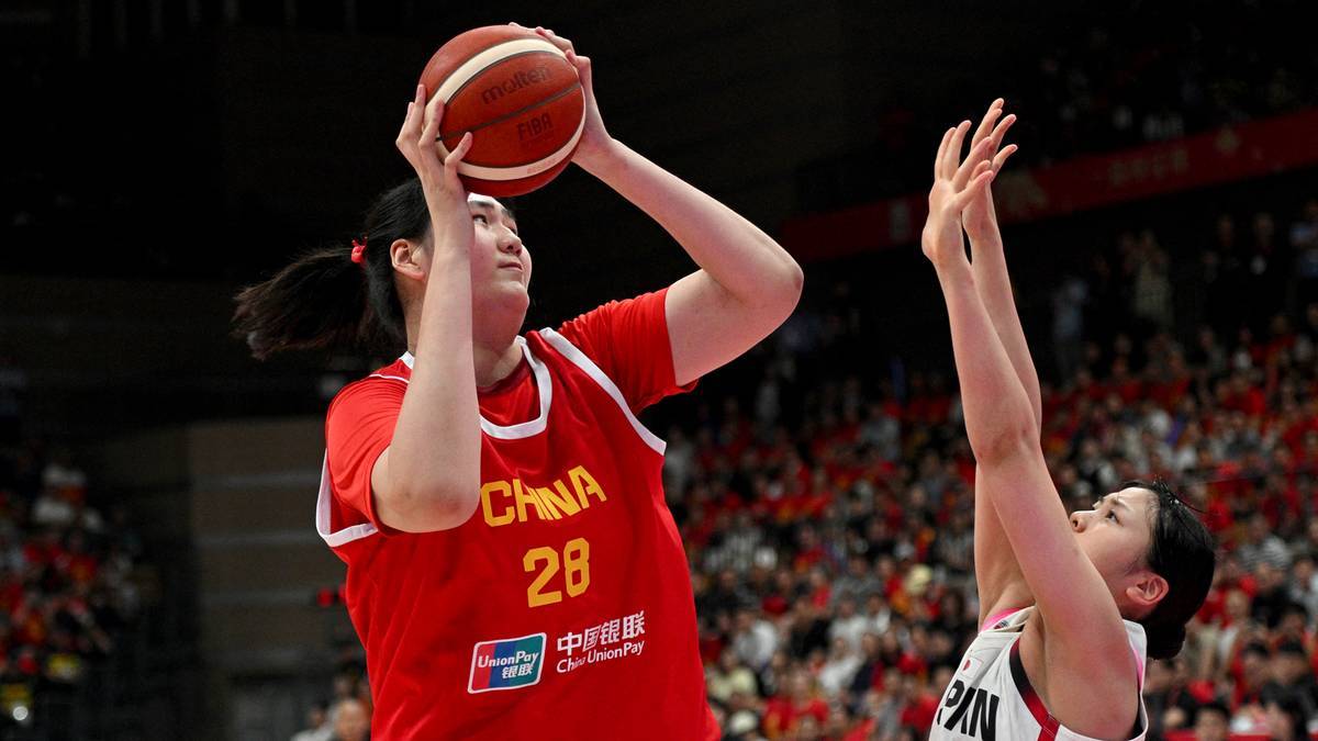 Zawodniczka koszykówki Zhang Ziyu w czerwonym stroju z numerem 28 "CHINA" oddaje rzut do kosza, podczas gdy przeciwniczka w białym stroju próbuje ją zablokować.