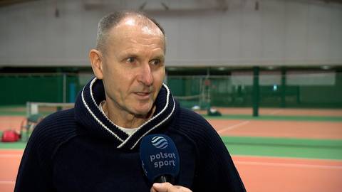 Mężczyzna w średnim wieku, prawdopodobnie ojciec tenisisty, udziela wywiadu. Trzyma mikrofon Polsat Sport.