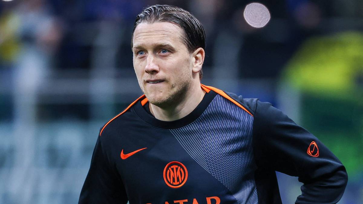 Piłkarz w koszulce Interu Mediolan biegnie po murawie stadionu.