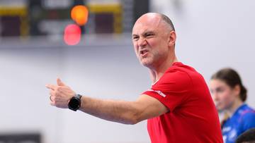 Trener drużyny szczypiornistek KRASOŃ MKS Piotrcovii podczas meczu, gestykulujący i wydający polecenia.