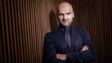 Portret Rafała Brzoski, prezesa InPostu, ze skrzyżowanymi ramionami.