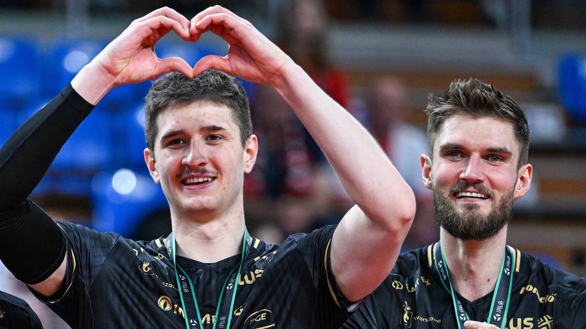 Trzech siatkarzy PGE Projekt Warszawa z medalami na szyjach, jeden z nich wykonuje gest serca dłońmi.