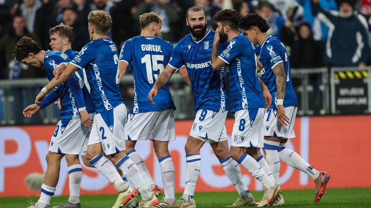 Piłkarze Lecha Poznań w niebieskich strojach świętują bramkę, wielu z nich przybija sobie piątki.