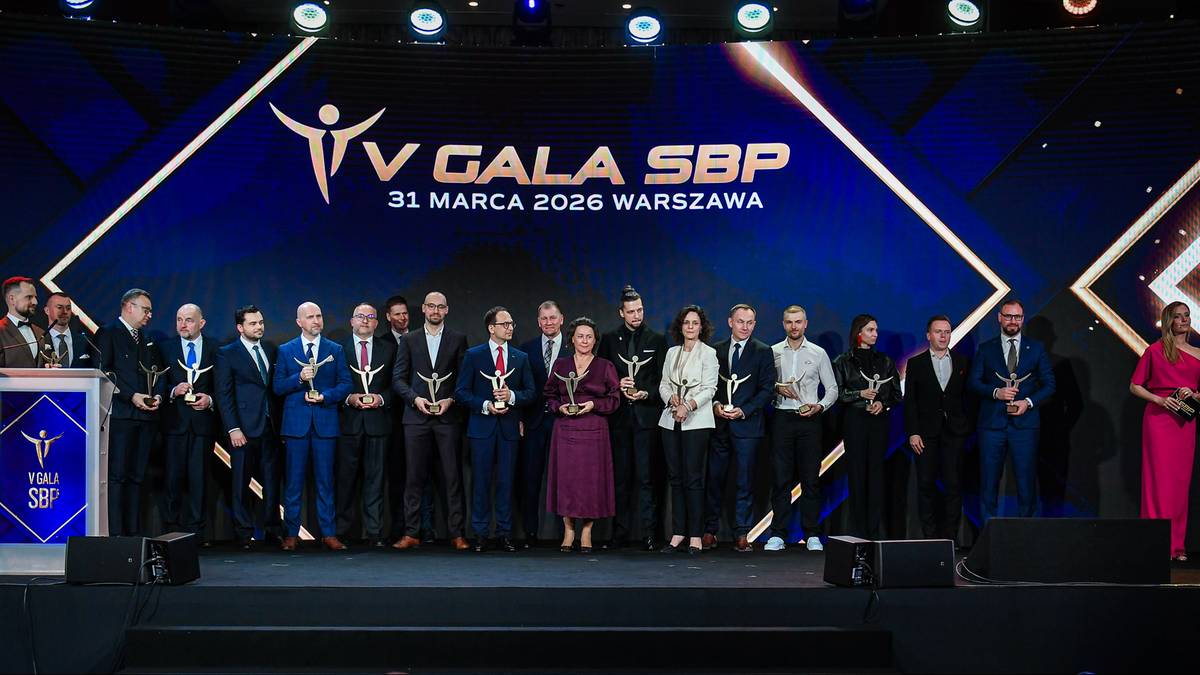 Grupa os&oacute;b stoi na scenie podczas V Gali Sport Biznes Polska, odbierając statuetki.