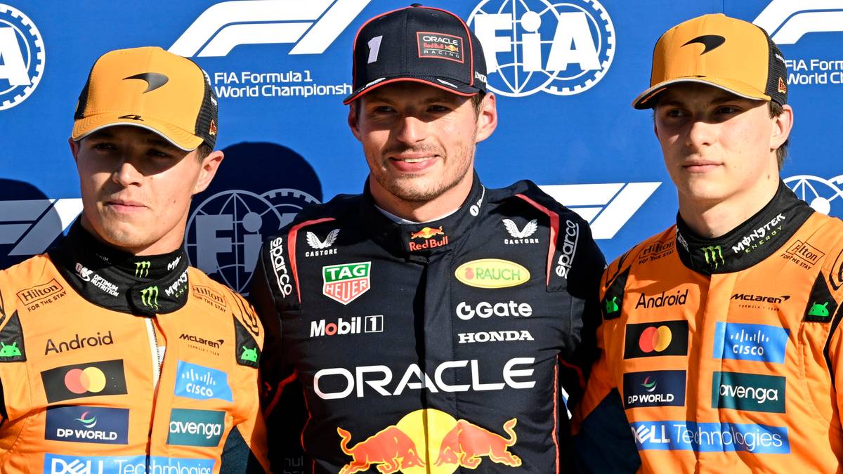 Max Verstappen w środku, otoczony przez dw&oacute;ch kierowc&oacute;w zespołu McLaren, Lando Norrisa po lewej i Oscara Piastriego po prawej. Wszyscy trzej noszą czapki i stroje zespołowe, z widocznymi logotypami sponsor&oacute;w.