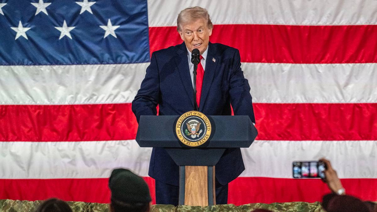 Donald Trump przemawia za mównicą na tle flagi USA.