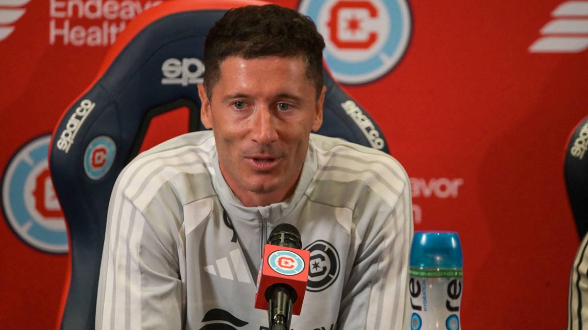 Robert Lewandowski siedzi przy mikrofonie w sali konferencyjnej.
