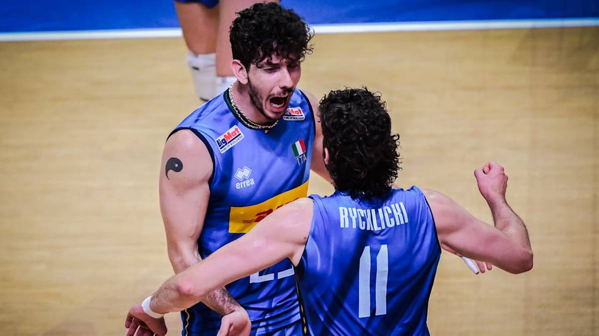 Dwóch siatkarzy w niebieskich strojach drużyny narodowej świętuje punkt, jeden z nich krzyczy z radości.