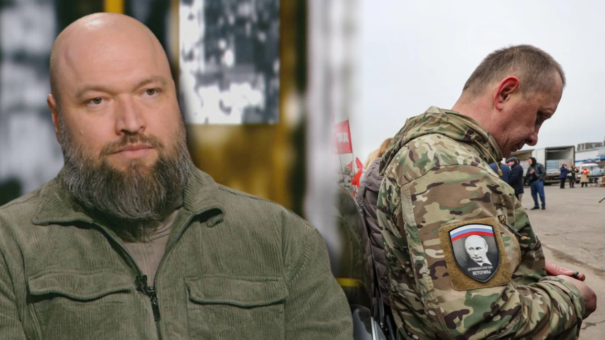 Mężczyzna z brodą w zielonej kurtce siedzi przed kamerą, po prawej stronie widok z tyłu na mężczyznę w mundurze z naszywką z wizerunkiem Władimira Putina.