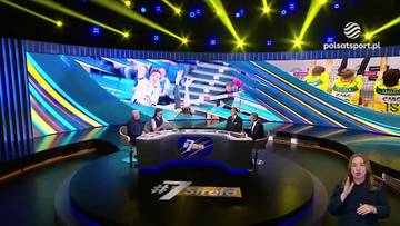 W studiu telewizyjnym, za okrągłym stołem siedzą cztery osoby, biorące udział w dyskusji. W tle znajduje się duży ekran z grafikami i zdjęciami sportowymi. Po prawej stronie obrazu, w rogu, stoi kobieta wskazująca gestem w stronę kamery.