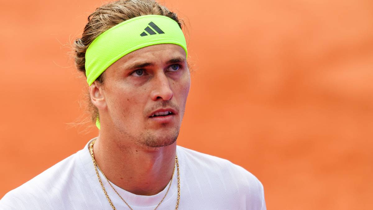 Portret tenisisty Alexandra Zvereva w neonowo-żółtej opasce na głowie i białej koszulce, z łańcuszkami na szyi, na pomarańczowym tle.