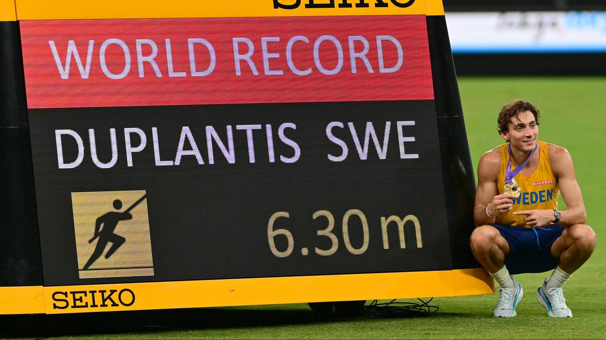 Armand Duplantis siedzi przy tablicy wyników informującej o pobiciu rekordu świata w skoku o tyczce z wynikiem 6.30 m.