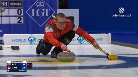 Zawodnik grający w curling podczas meczu Polska - Kanada, wykonujący rzut kamieniem.