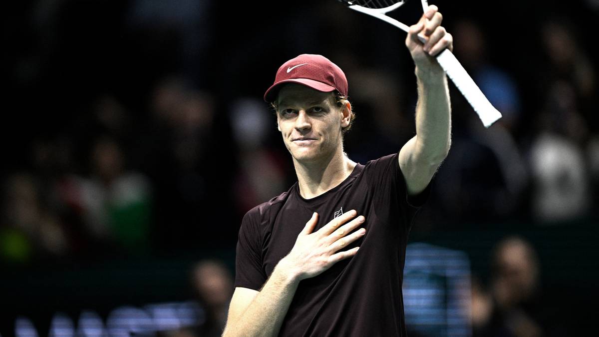 Jannik Sinner z rakietą tenisową w g&oacute;rze, z dłonią na piersi.