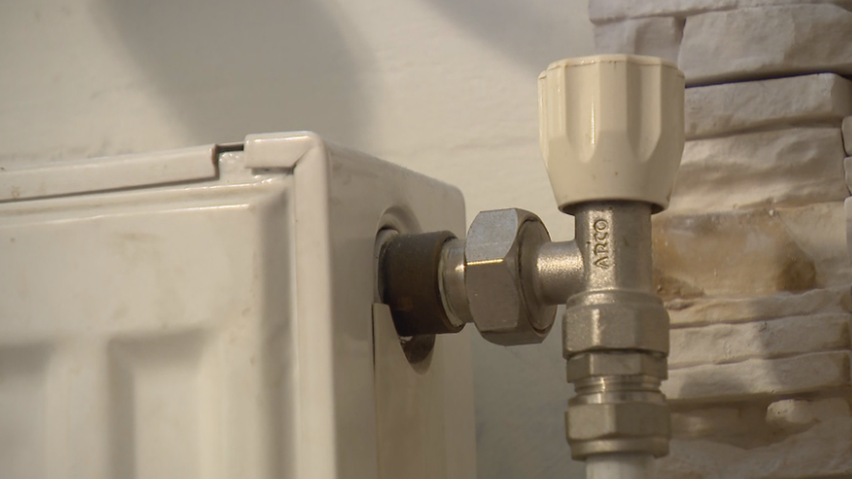 Fragment grzejnika centralnego ogrzewania z widocznym zaworem termostatycznym.