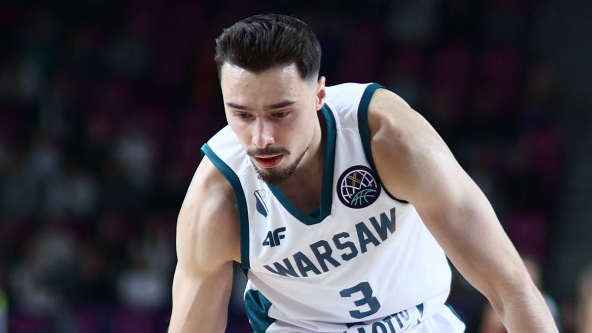 Koszykarz Legii Warszawa prowadzi piłkę podczas meczu, kryty przez przeciwnika.