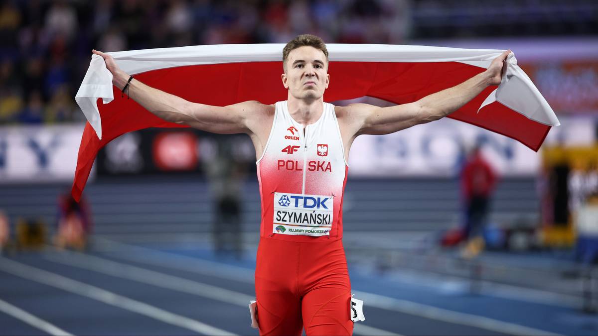 Polski lekkoatleta biegnie z biało-czerwoną flagą na ramionach, świętując zwycięstwo.
