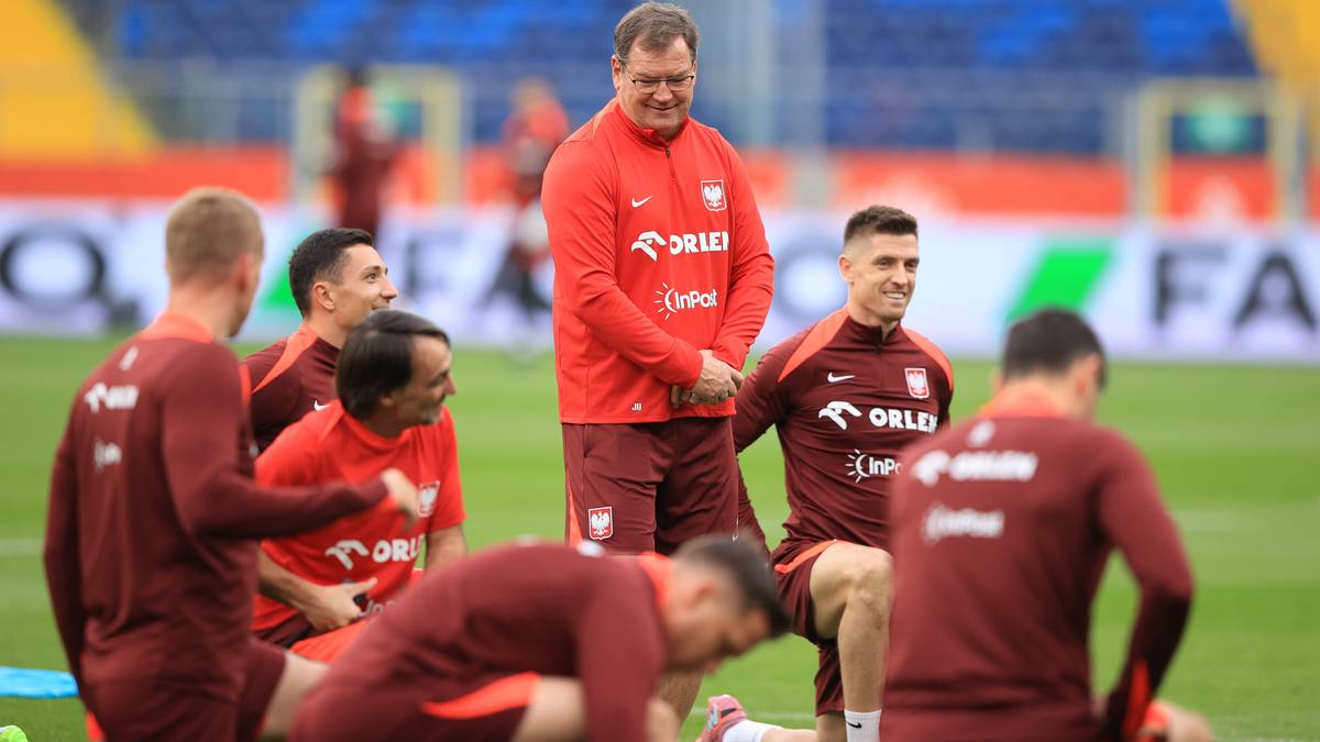 Grupa piłkarzy w strojach reprezentacji Polski podczas treningu na boisku.