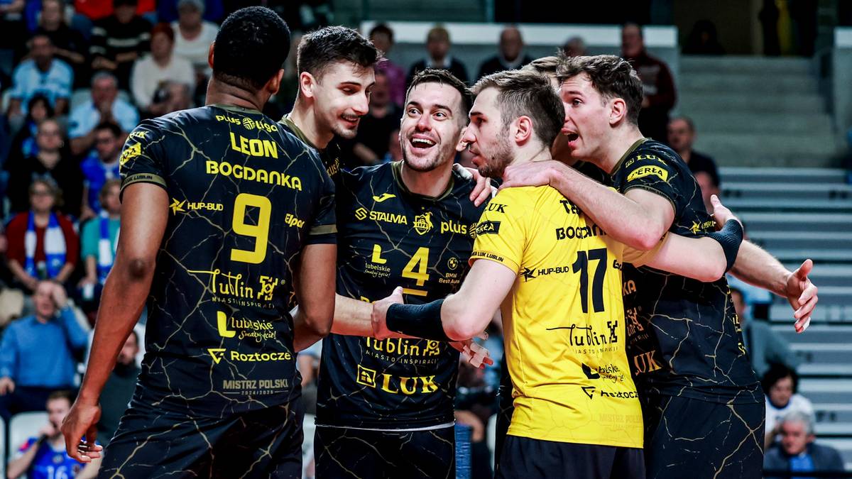 Siatkarze w czarno-ż&oacute;łtych strojach świętują zwycięstwo, trzymając się nawzajem.