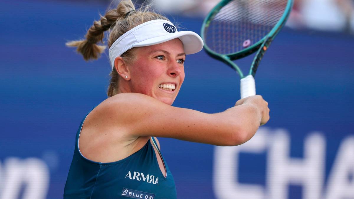 Tenisistka Magdalena Fręch w akcji, podczas meczu z rakietą w ręku, skupiona na uderzeniu.