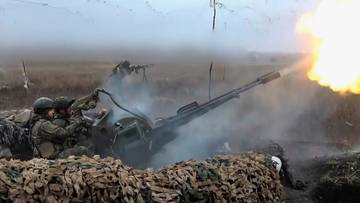 Artyleria ostrzeliwuje pozycje przeciwnika na polu bitwy, unoszą się kłęby dymu i pyłu.