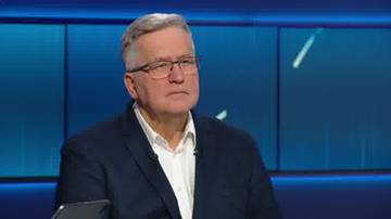 Starszy mężczyzna w okularach i ciemnej marynarce siedzi w studiu telewizyjnym.