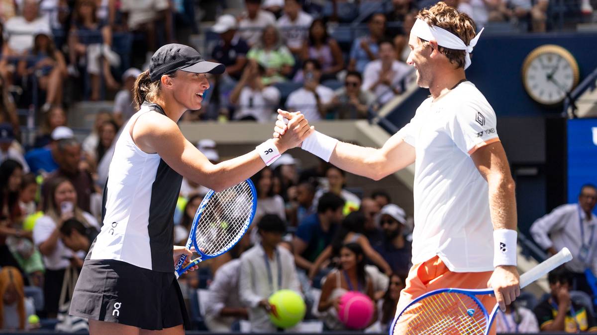 Iga Świątek i jej rywal podają sobie ręce po meczu tenisa.