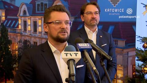 Marcin Krupa, prezydent Katowic, w garniturze i okularach, przemawia do mikrofonu. Za nim stoi drugi mężczyzna.