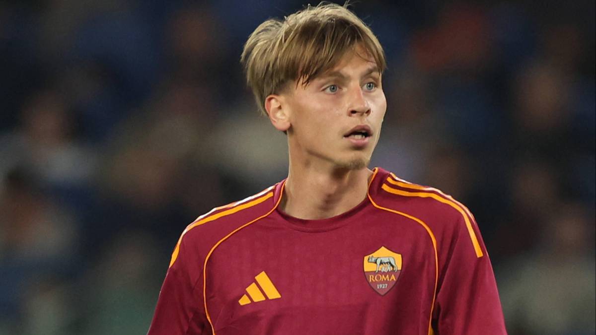 Młody piłkarz w bordowej koszulce AS Roma na boisku.