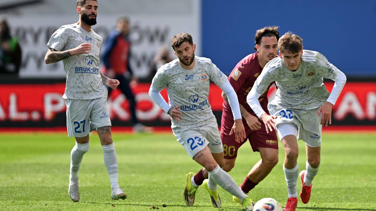 Piłkarze walczący o piłkę na boisku podczas meczu piłki nożnej.