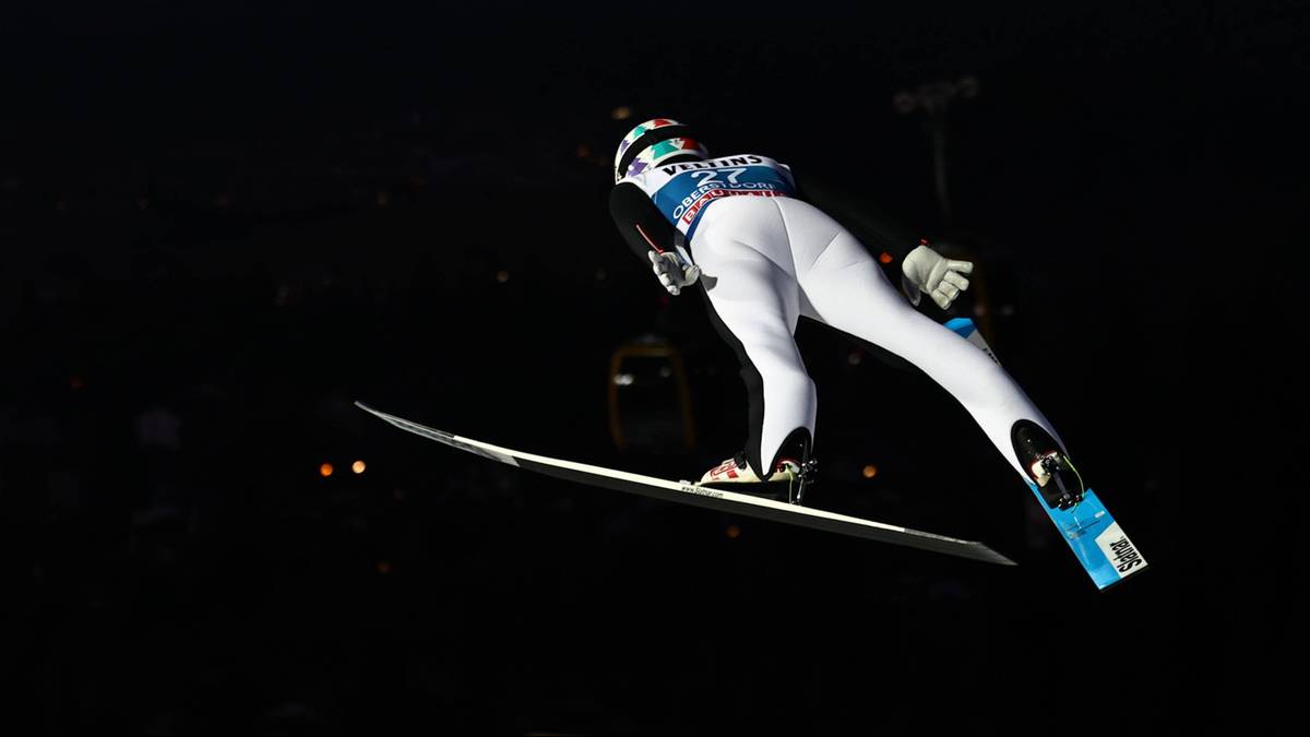 Skoczek narciarski w locie podczas zawod&oacute;w.