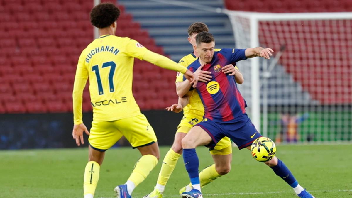 Piłkarz w granatowo-czerwonym stroju Barcelony pr&oacute;buje zagrać piłkę podczas meczu, z dwoma przeciwnikami w ż&oacute;łtych strojach.