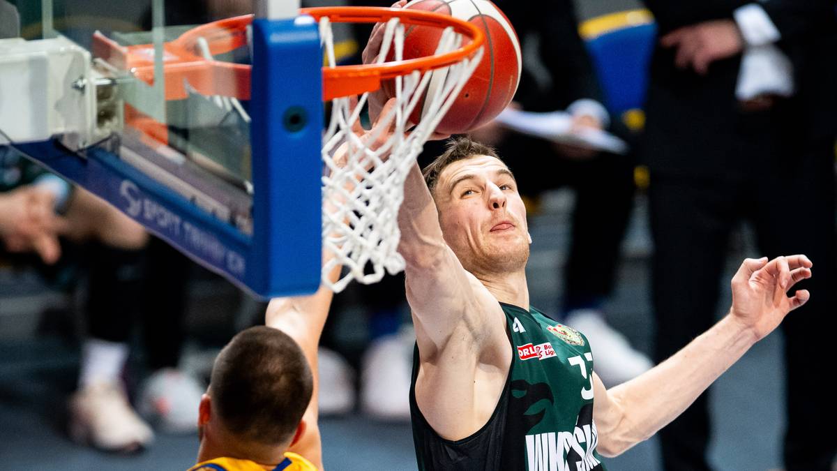 Gracz w koszykówce w czarnej koszulce z numerem 33 na plecach wykonuje rzut do kosza w trakcie meczu.