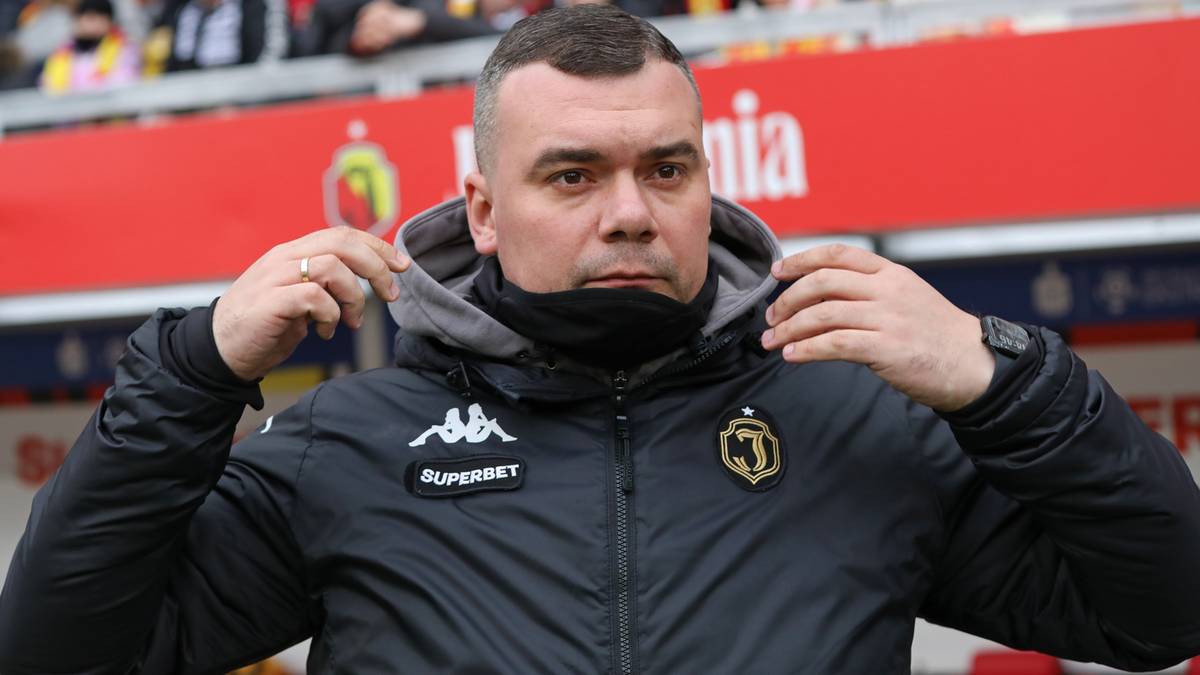 Mężczyzna w czarnej kurtce z kapturem, trener Jagiellonii Białystok, Adrian Siemieniec.