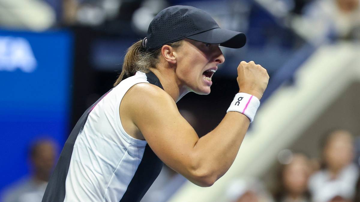 Iga Świątek podczas meczu tenisowego, triumfująca i podnosząca pięść w geście radości.