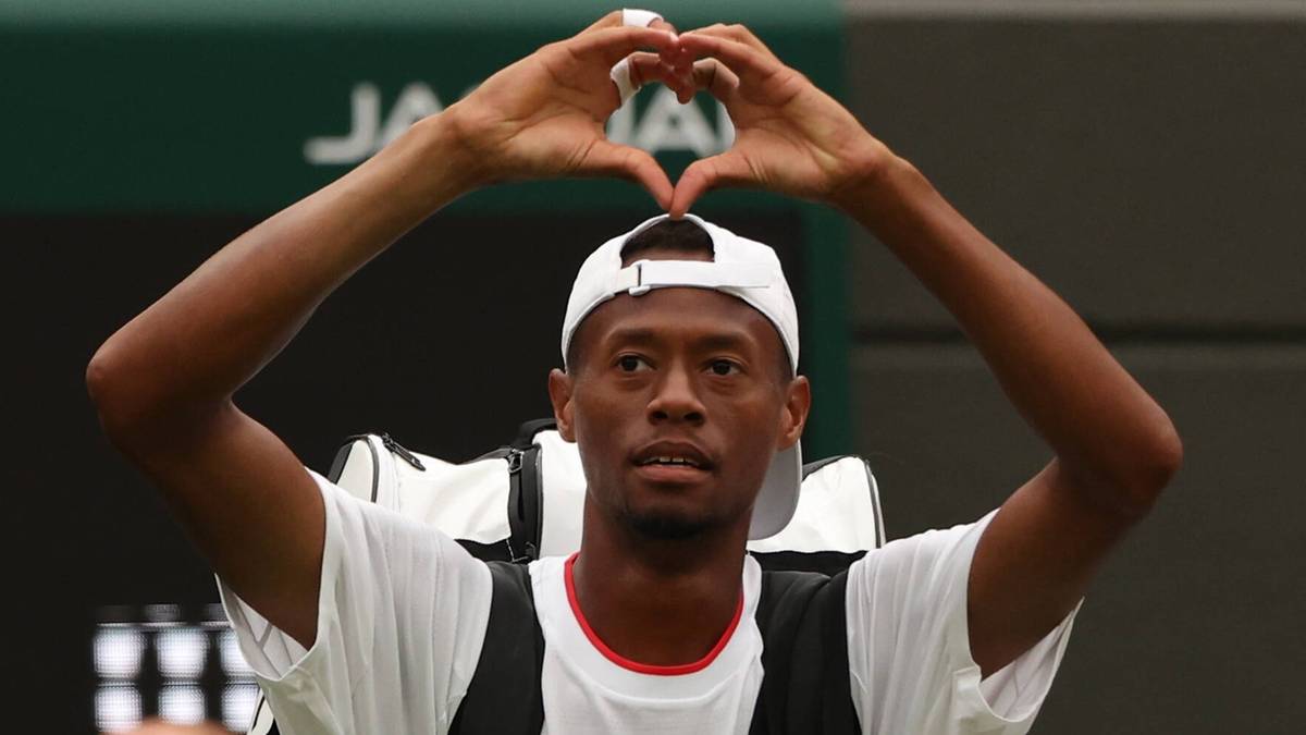 Christopher Eubanks, tenisista, robi gest serca dłońmi nad głową.