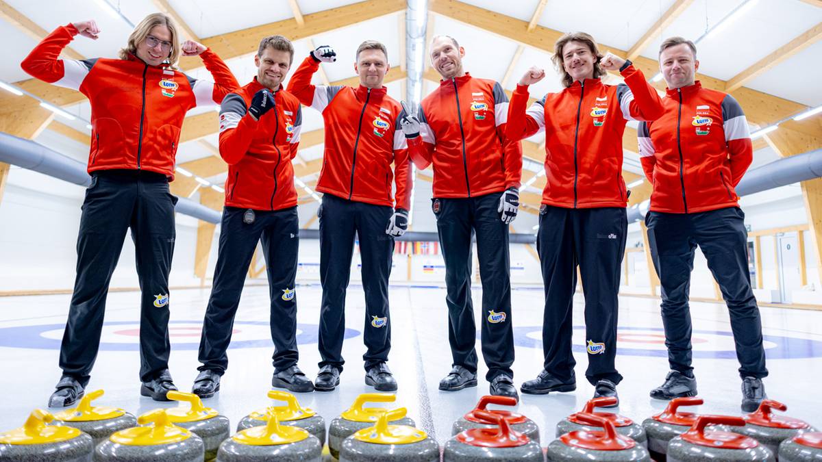 Drużyna curlingowa mężczyzn w czerwonych strojach pozuje z kamieniami do curlingu.