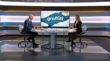 Dw&oacute;ch rozm&oacute;wc&oacute;w siedzi przy okrągłym stole w studiu telewizyjnym. Na ekranie za nimi widnieje logo "graffiti".