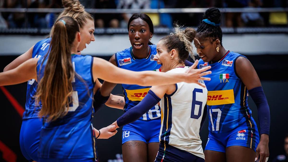 Pięć zawodniczek w niebieskich strojach świętuje zwycięstwo na boisku do siatkówki.