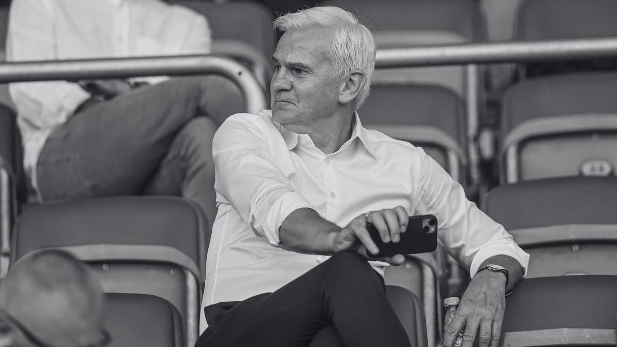 Mężczyzna siedzący na trybunach stadionu piłkarskiego.