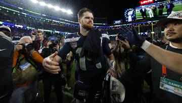 Gracz Seahawks Kenneth Walker w otoczeniu tłumu i fotoreporter&oacute;w, świętujący zwycięstwo.