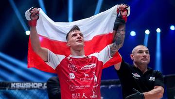 Młody mężczyzna w czerwonej koszulce sportowej trzyma uniesioną biało-czerwoną flagę Polski.