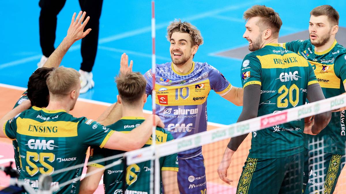 Siatkarze Aluron CMC Warta Zawiercie celebrują zwycięstwo na boisku, podając sobie dłonie i okazując radość.