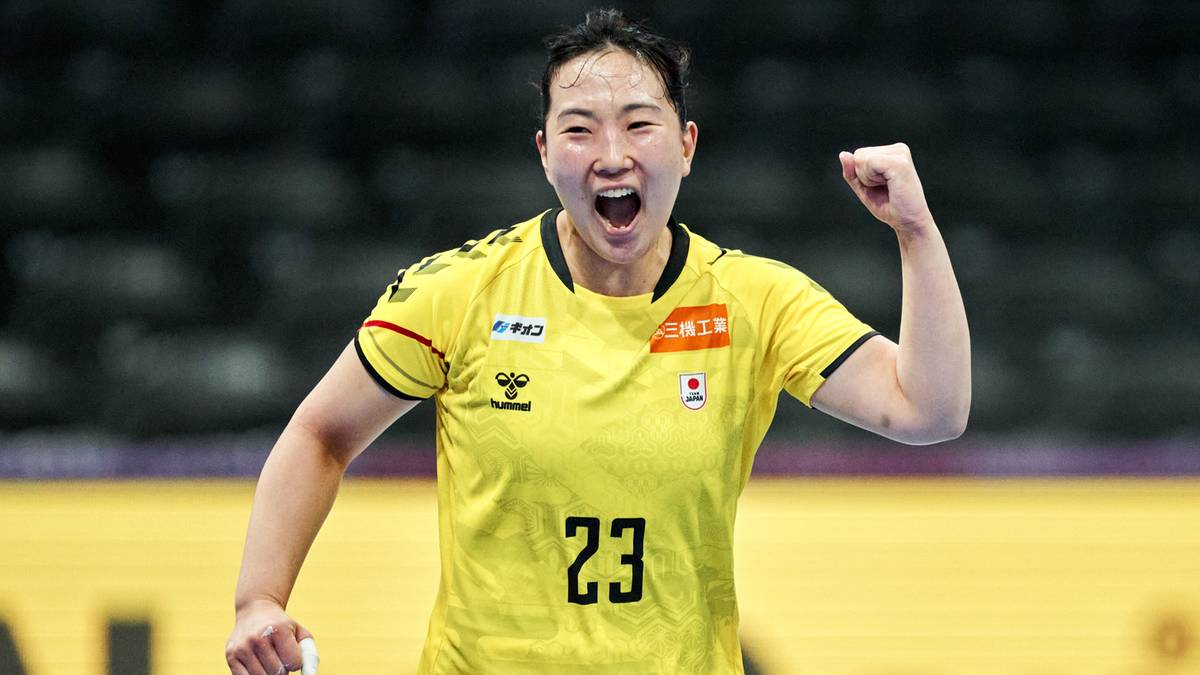 Zawodniczka reprezentacji Japonii w piłce ręcznej w żółtej koszulce z numerem 23, unosi zaciśniętą pięść w geście radości.