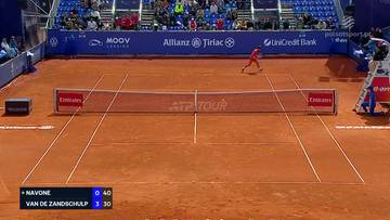 Gracz tenisa na korcie ziemnym podczas meczu z widocznym wynikiem.