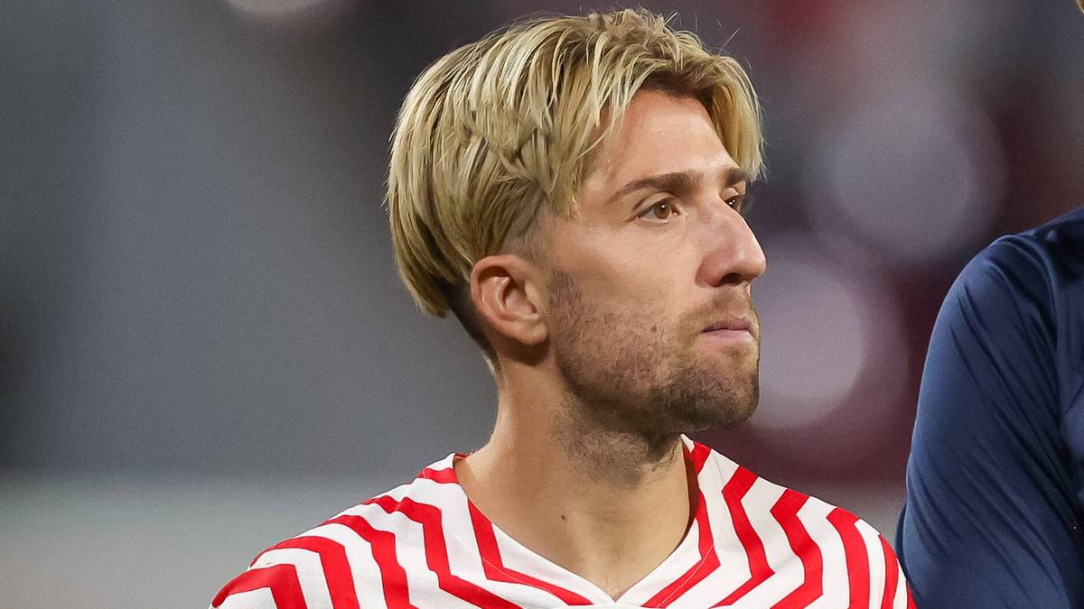 Dw&oacute;ch piłkarzy w strojach sportowych rozmawia ze sobą.