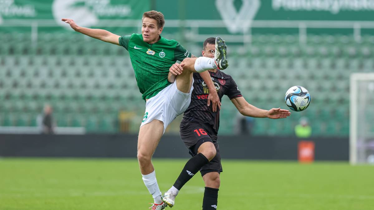 Dwóch piłkarzy walczy o piłkę podczas meczu.