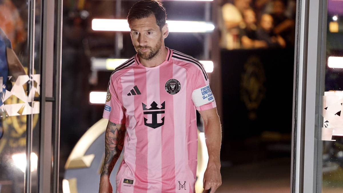 Piłkarz Lionel Messi w różowej koszulce z czarnymi pasami i herbem klubu Inter Miami